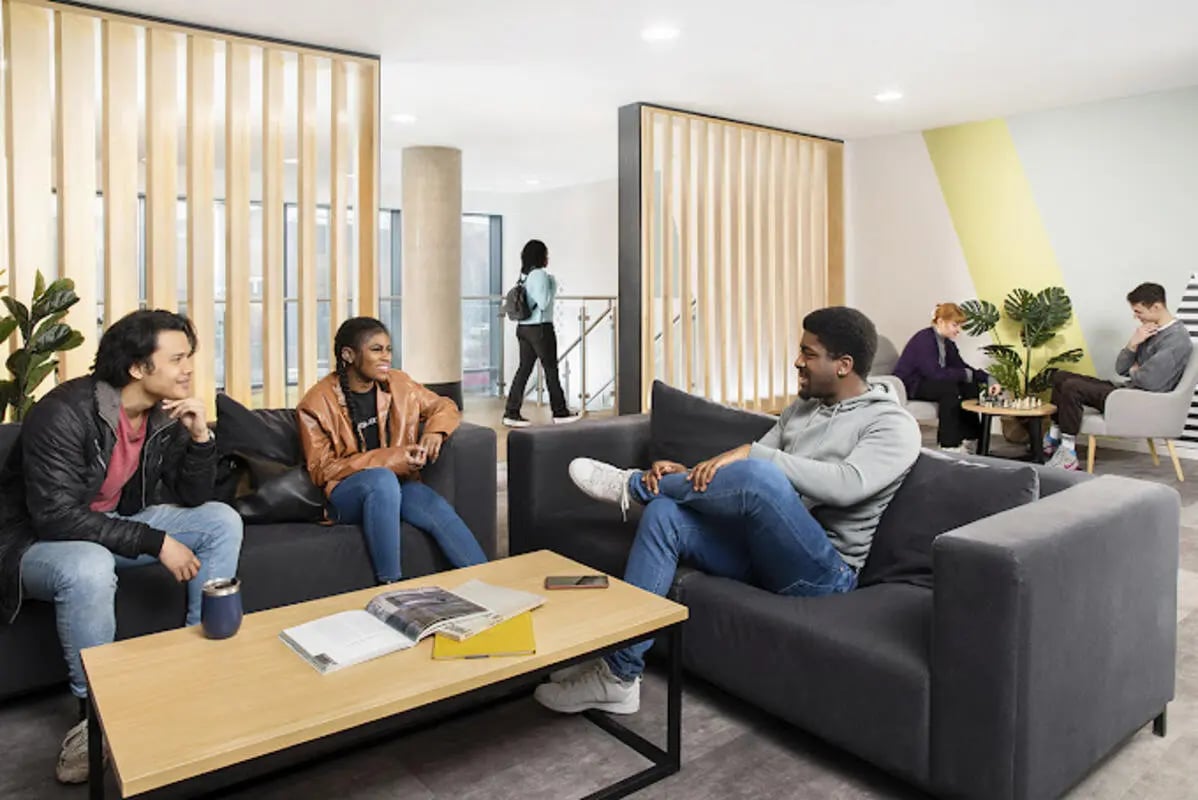 Students relaxing on sofas coffee table living room at Staniforth House in Birmingham Student Accommodation