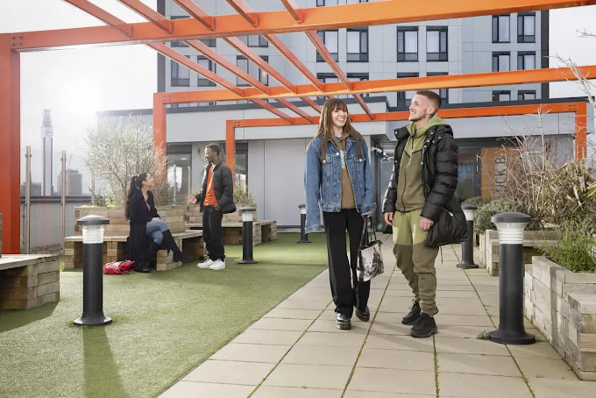 People walking on rooftop patio with urban view at Staniforth House in Birmingham Student Accommodation