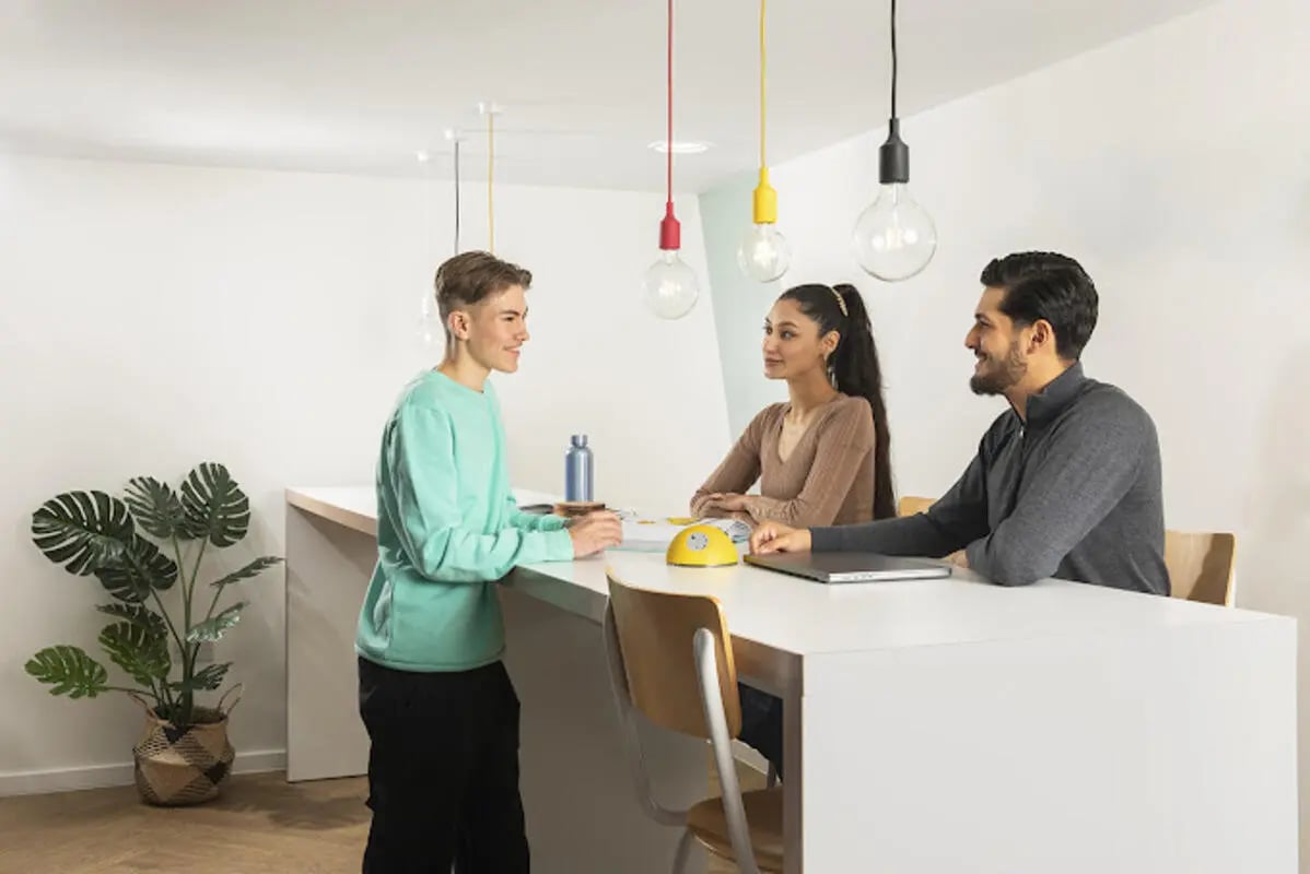 Three students talking at a counter study area at Staniforth House in Birmingham Student Accommodation