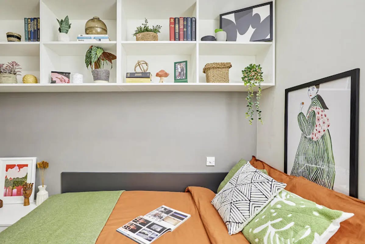 Bed with orange duvet green throw and art Bedroom at Staniforth House in Birmingham Student Accommodation
