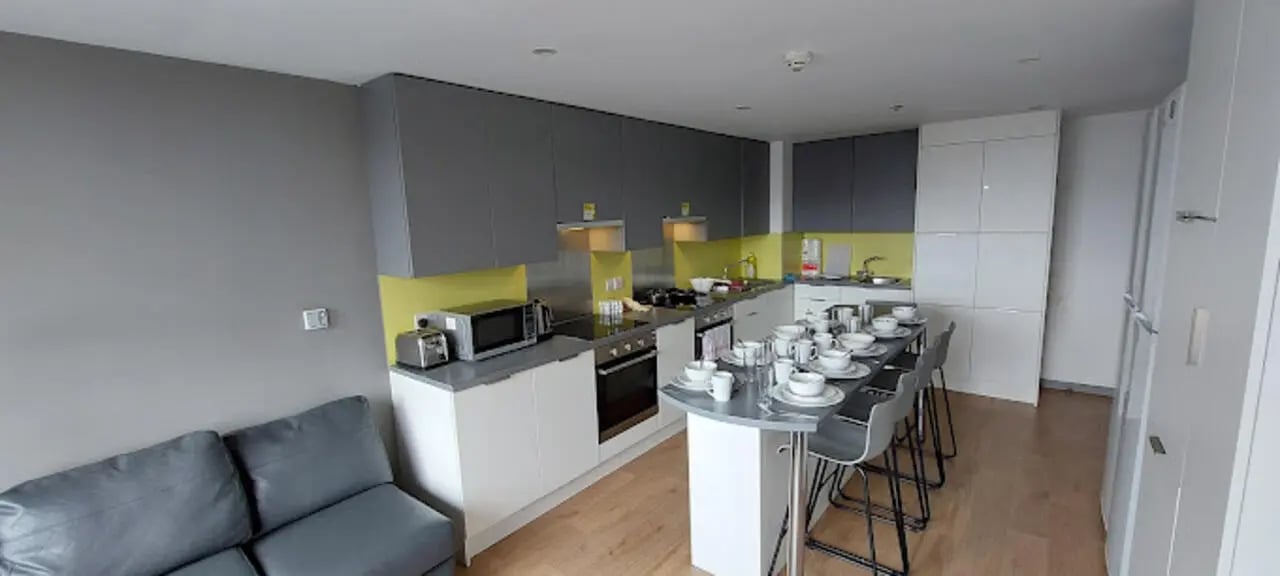 Modern kitchen with dining island and sofa at Staniforth House in Birmingham Student Accommodation