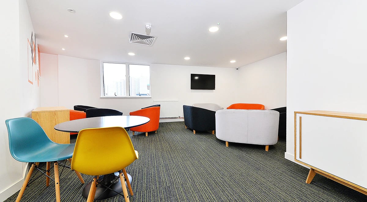 Colorful chairs round table lounge area living room at Miura in Nottingham Student Accommodation