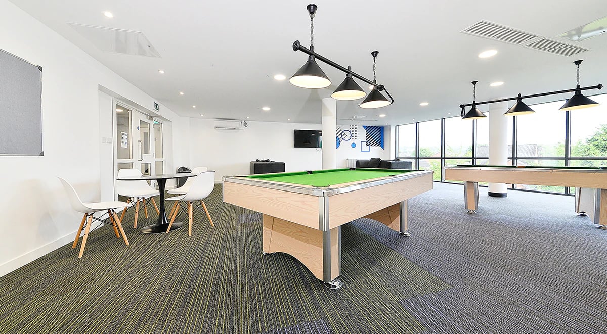 Pool tables seating area and large windows recreation room at Miura in Nottingham Student Accommodation