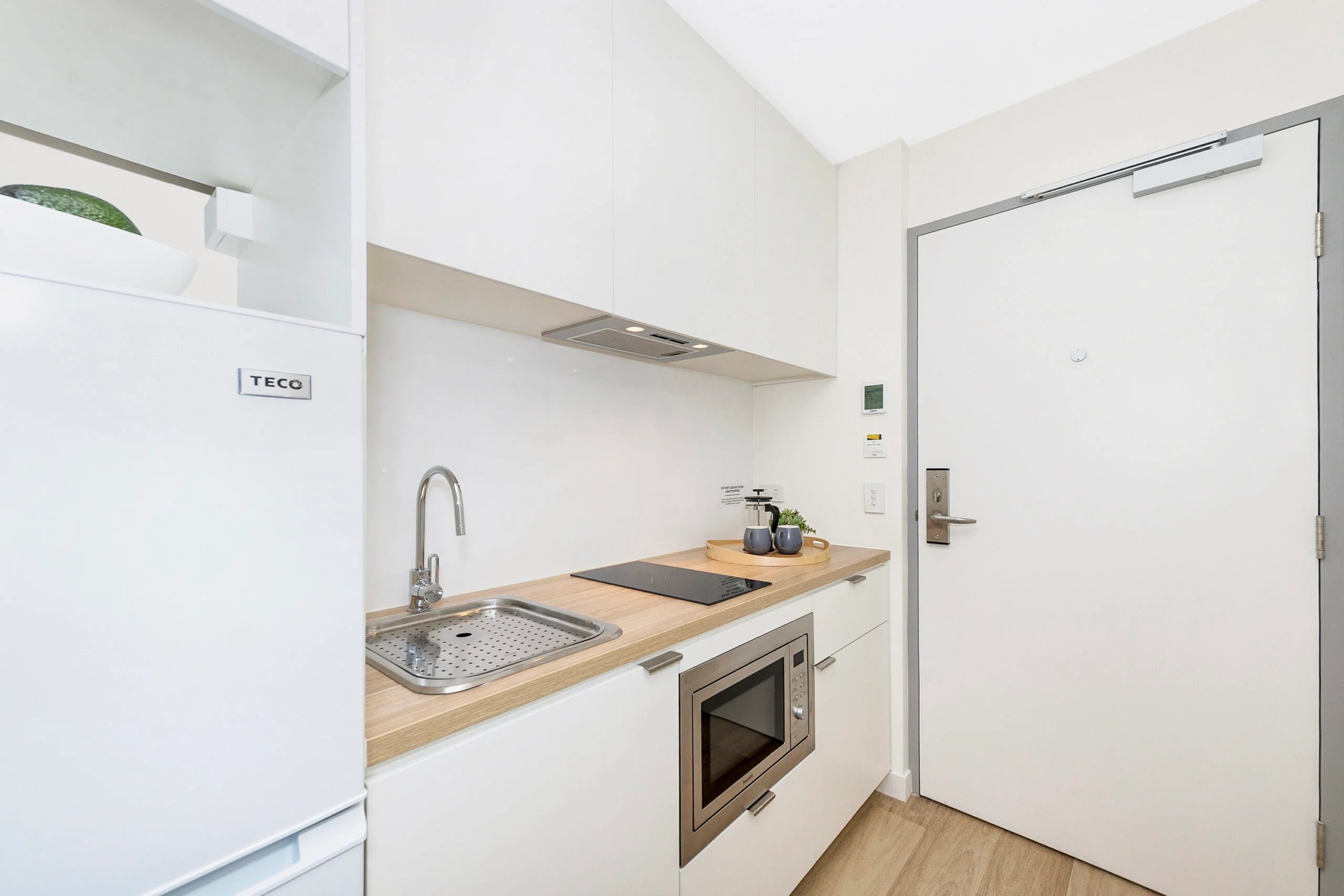 Sink induction hob microwave with door Kitchen at Scape St Lucia in Brisbane Student Accommodation