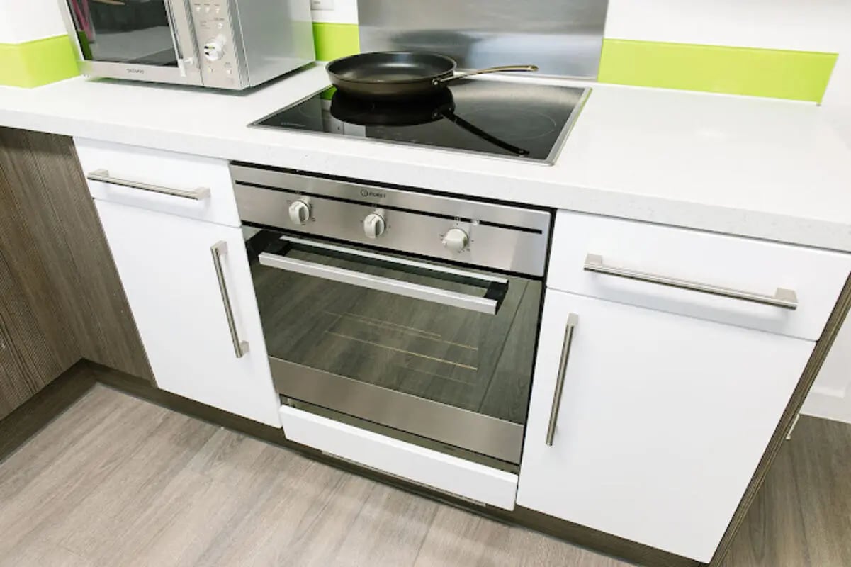 Oven and induction hob with microwave kitchen at Queen's Park House in Coventry Student Accommodation