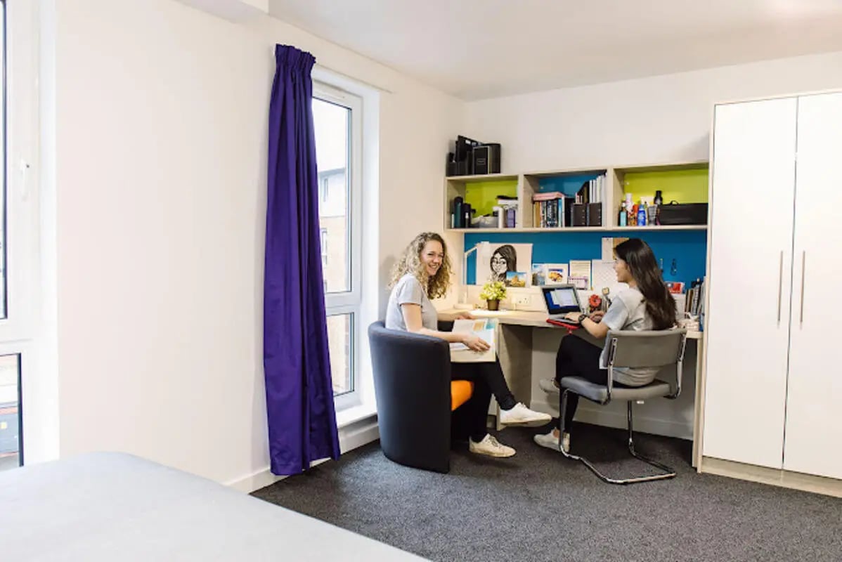 Two students studying at desks white wardrobe study area at Queen's Park House in Coventry Student Accommodation