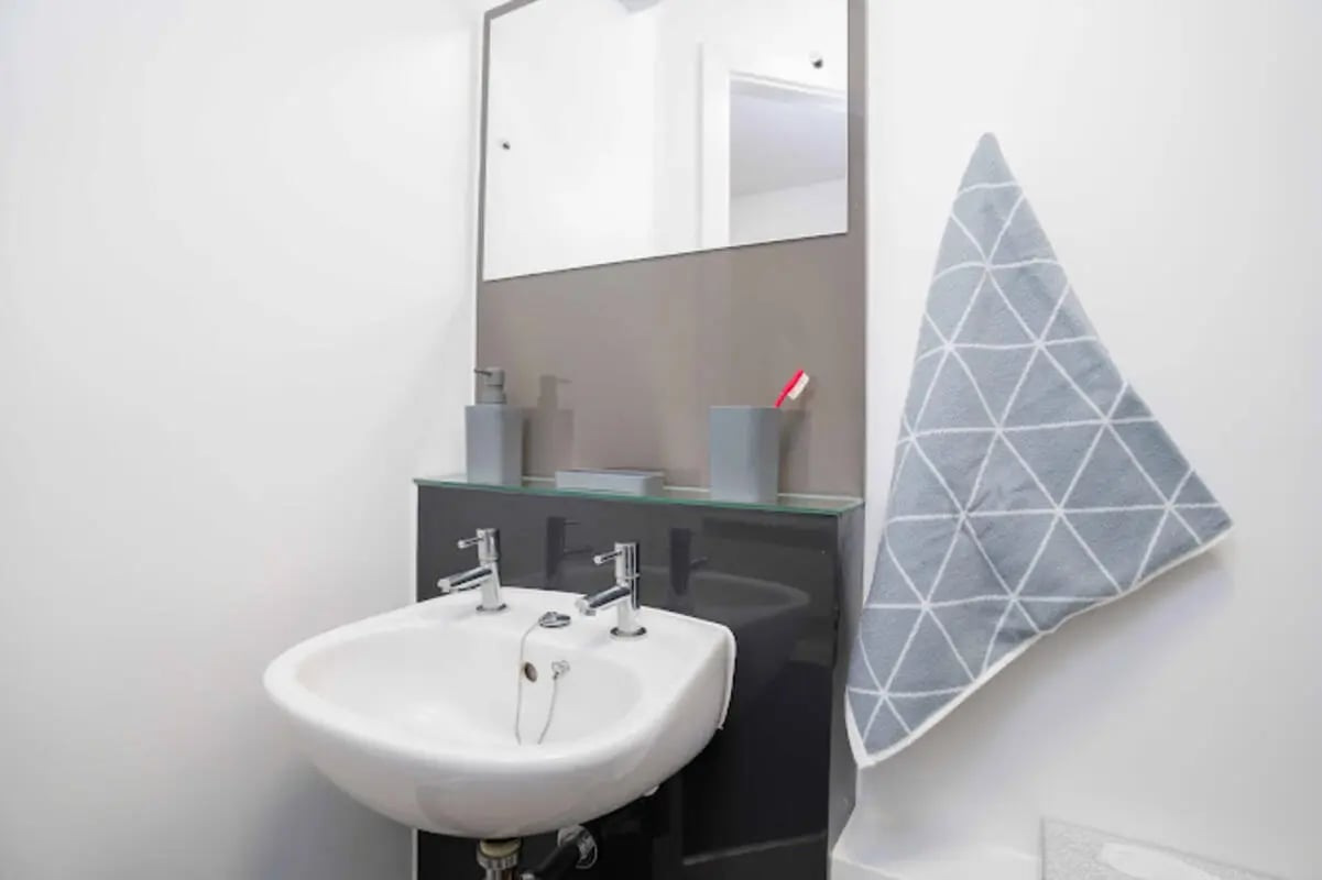 White sink mirror soap dispenser towel bathroom at Queen's Park House in Coventry Student Accommodation