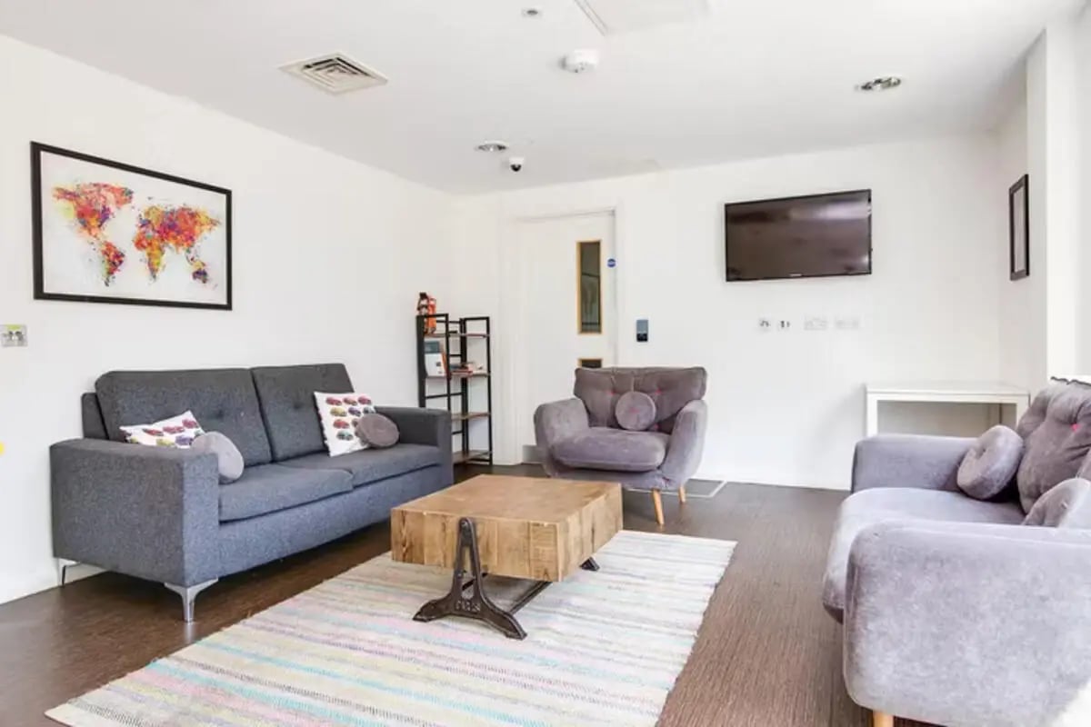 Sofa armchairs coffee table rug living room at Lucas Studios in Birmingham Student Accommodation