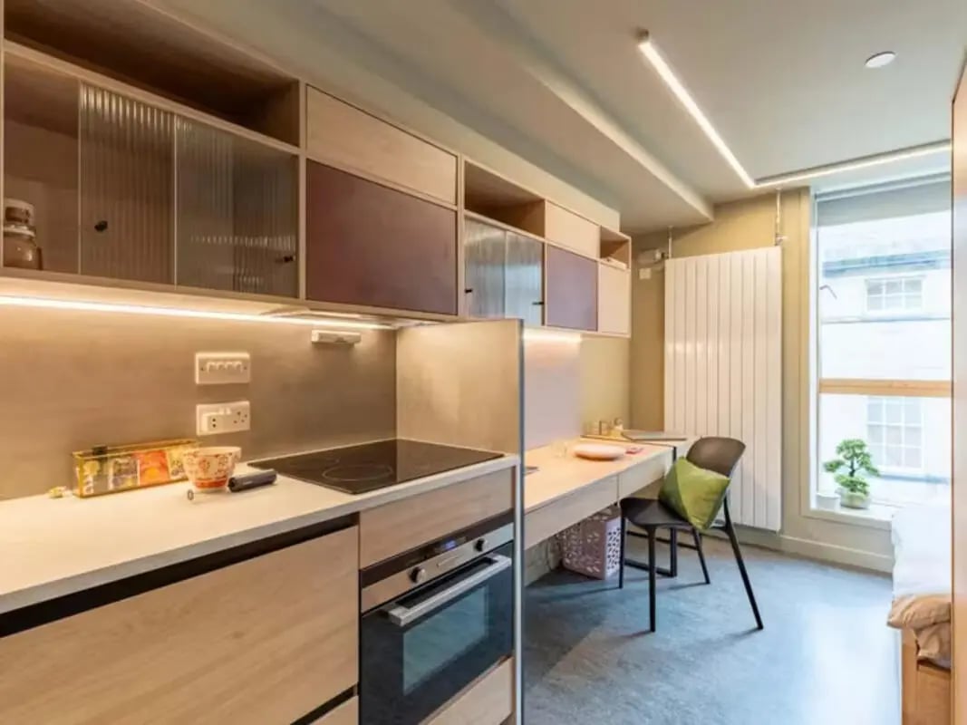 Kitchenette with stovetop oven and desk area living room at Potterrow in Edinburgh Student Accommodation