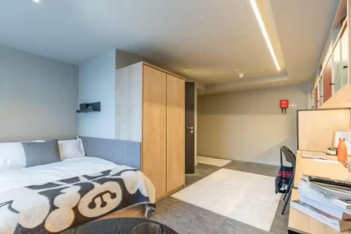 Bed wardrobe desk with chair and laptop bedroom at Potterrow in Edinburgh Student Accommodation