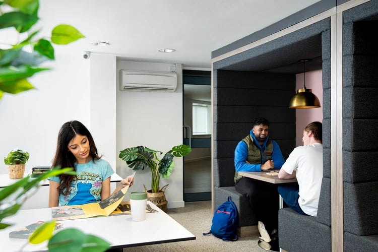 Students studying in booth and at desk communal area at Castle Court in Leicester Student Accommodation