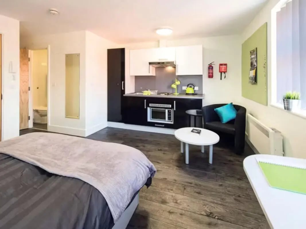 Bed kitchen chairs table bathroom visible living room at Ty Ni in Bangor Student Accommodation
