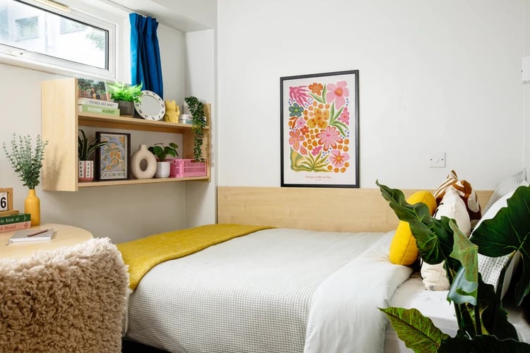 Bed with yellow throw artwork and desk Bedroom at Liberty Park in Leicester Student Accommodation