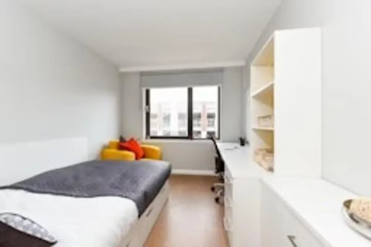 Bed desk chair bookshelf yellow chair bedroom at Merchant Studios in Glasgow Student Accommodation