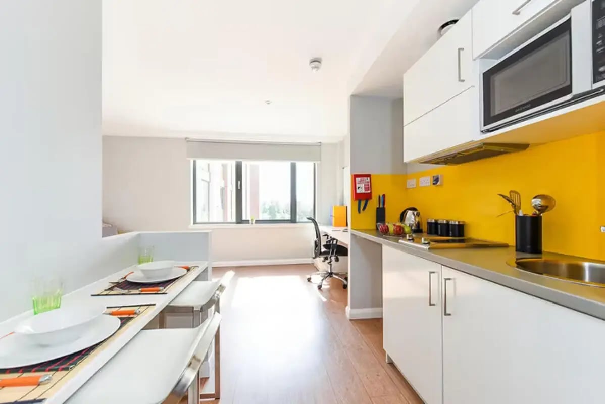 Dining area with white table and chairs kitchen Living room at Merchant Studios in Glasgow Student Accommodation