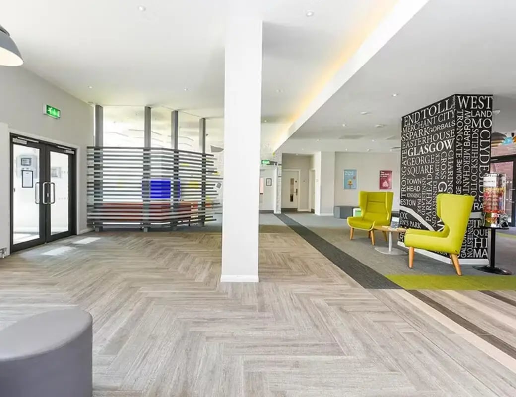 Modern lobby with lime chairs and city names wall at Merchant Studios in Glasgow Student Accommodation