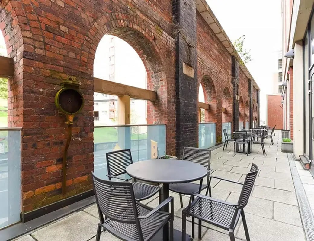 Outdoor seating area with tables and chairs exterior at Merchant Studios in Glasgow Student Accommodation