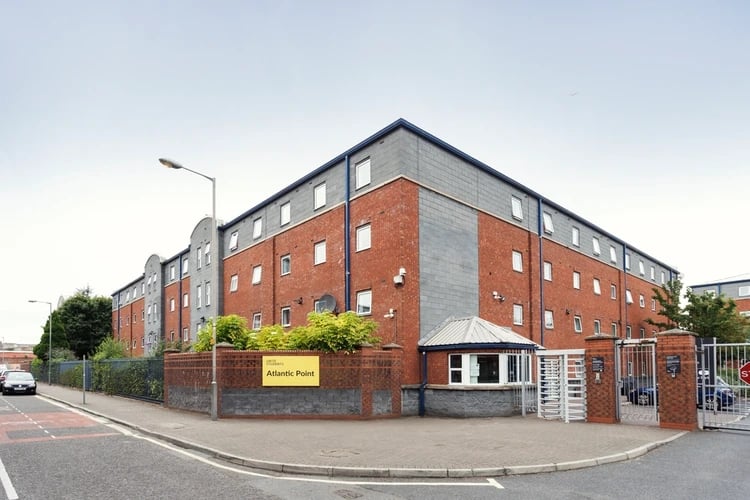 Brick building with windows and fence exterior at Atlantic Point in Liverpool Student Accommodation
