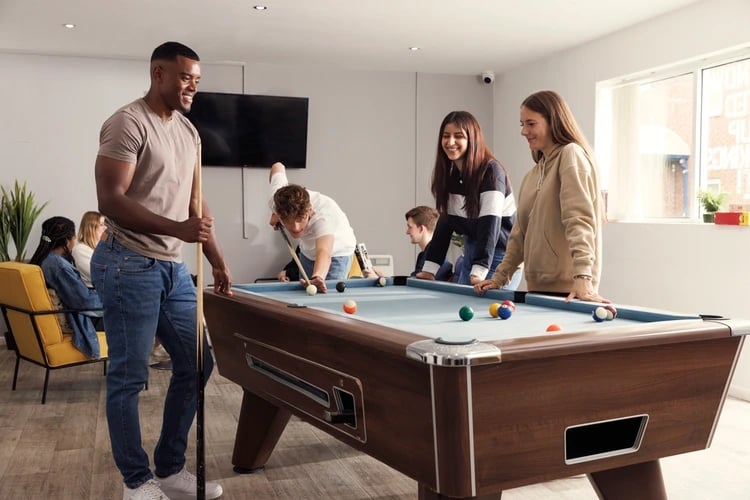Students play pool in a common room. at Atlantic Point in Liverpool Student Accommodation