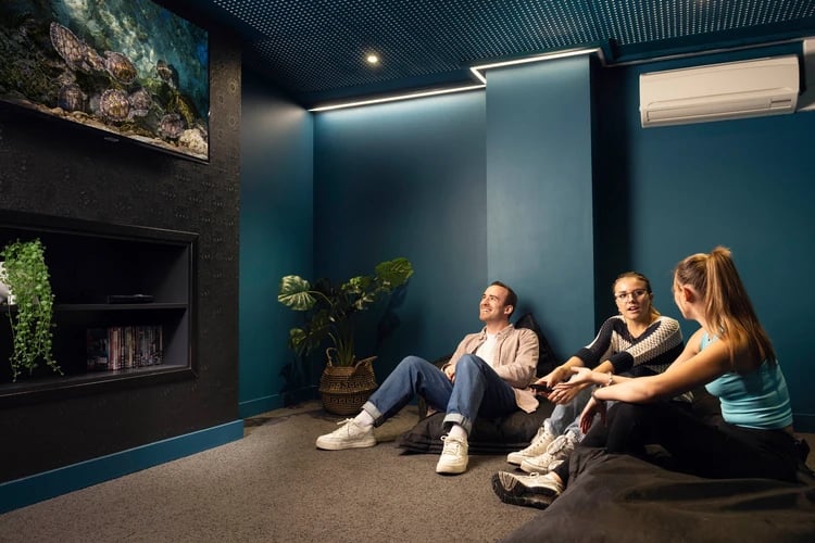 People relaxing on beanbags watching television entertainment room at Moorfield in Liverpool Student Accommodation