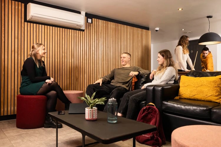 Students relaxing on sofas near pool table living room at Moorfield in Liverpool Student Accommodation