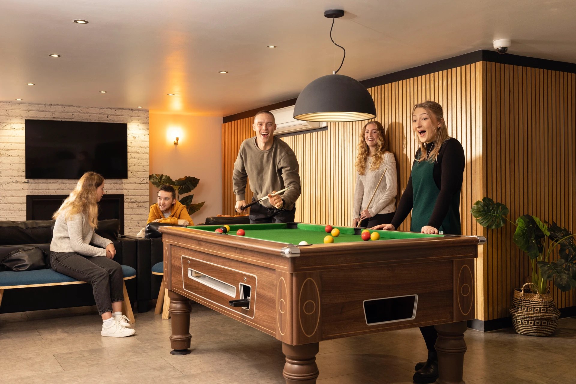 Students playing billiards on a pool table living room at Moorfield in Liverpool Student Accommodation