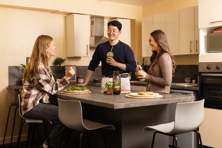 Three students chatting in a modern kitchen Kitchen at Moorfield in Liverpool Student Accommodation