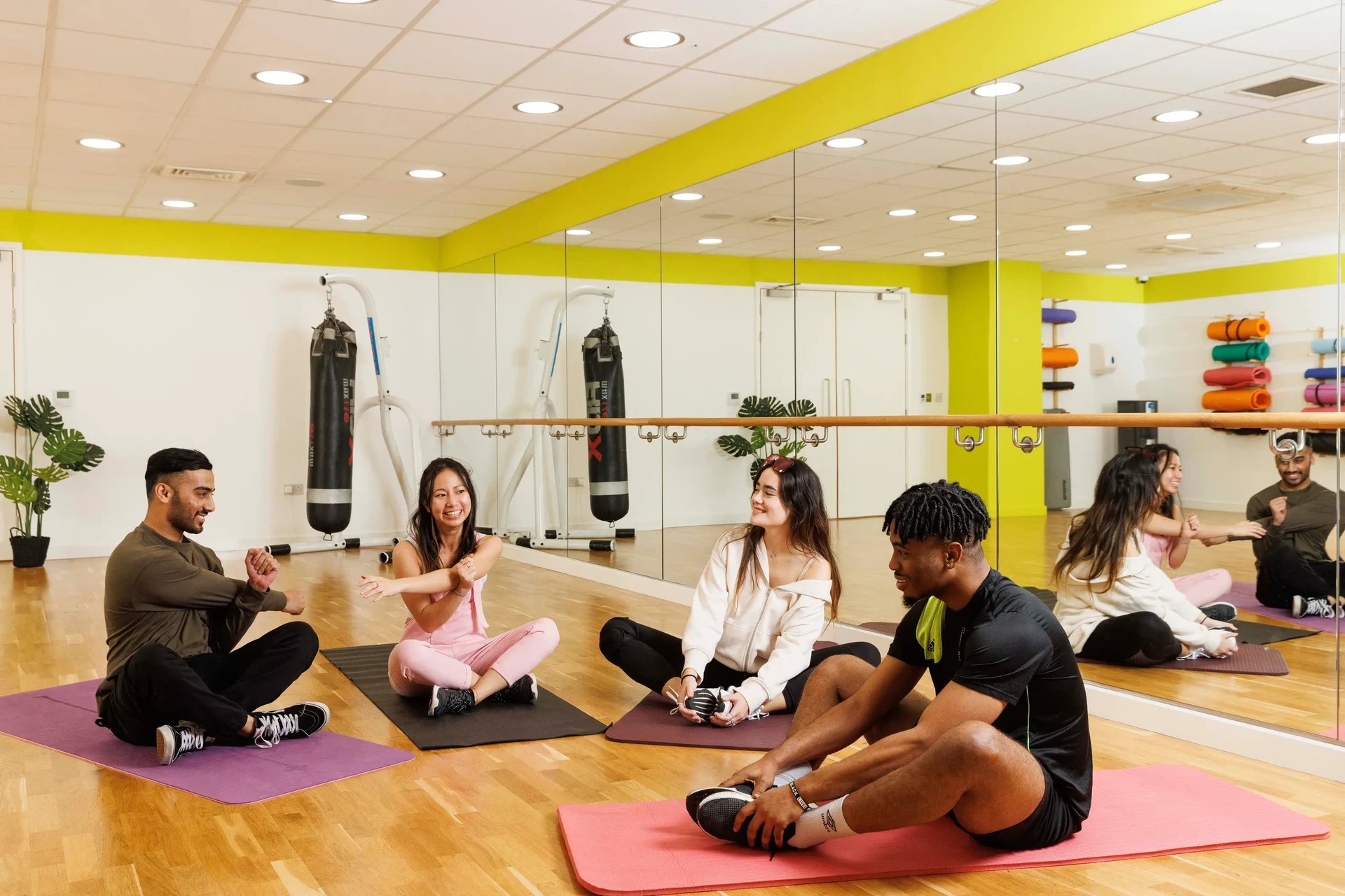 Students stretching on yoga mats in gym at Drapery Place in London Student Accommodation
