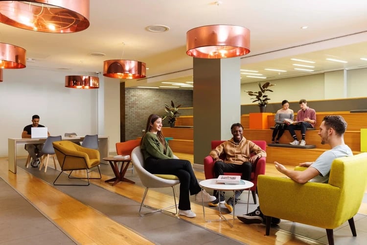 Students lounge chairs and benches common area at Drapery Place in London Student Accommodation