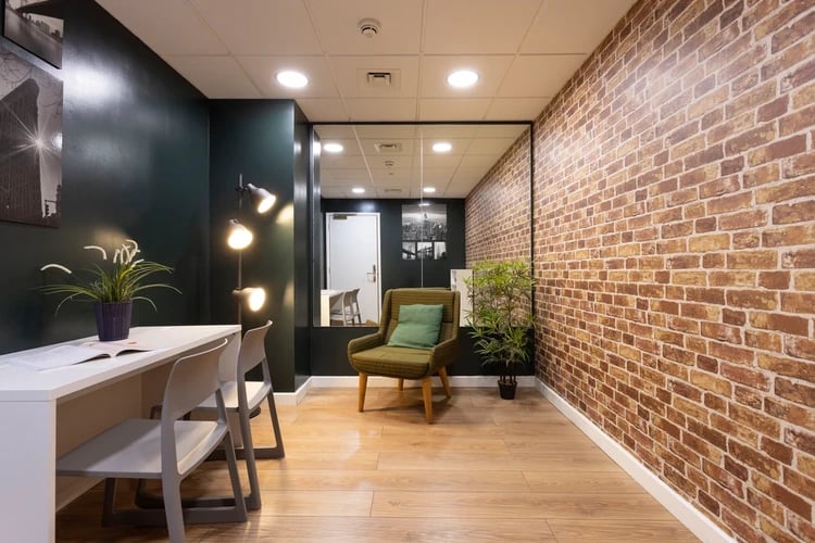 White desk chairs plant accent chair lounge area at Drapery Place in London Student Accommodation