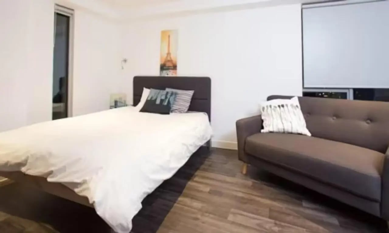 Bed with pillows sofa with cushion bedroom at Edge Apartments in Birmingham Student Accommodation