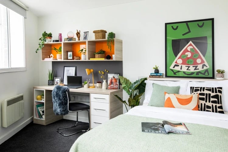 Desk with laptop shelves bed with pillows bedroom at Arbour House in London Student Accommodation