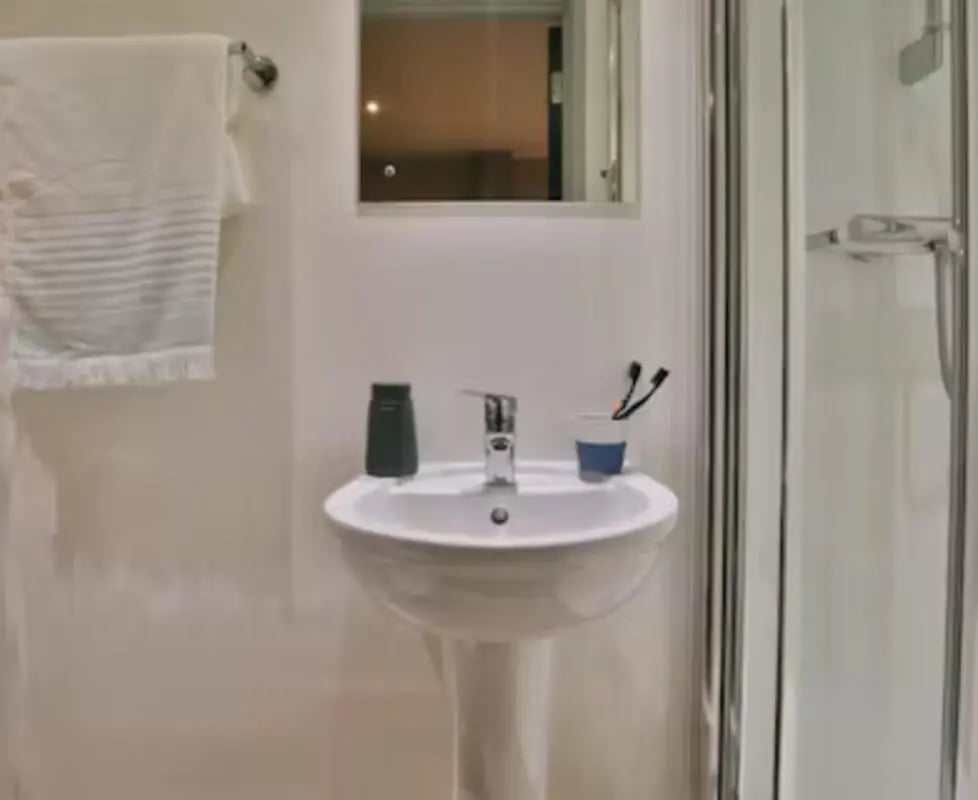 Sink mirror towel and shower enclosure bathroom at College Green in Bristol Student Accommodation