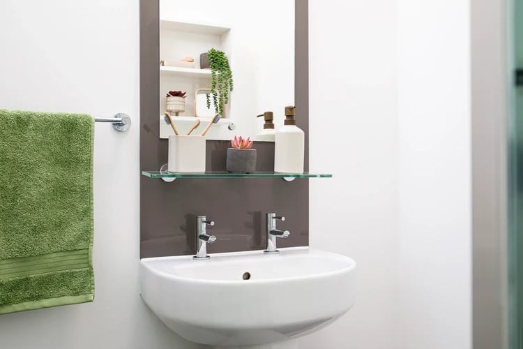 Sink with green towel and toiletries bathroom at Arbour House in London Student Accommodation