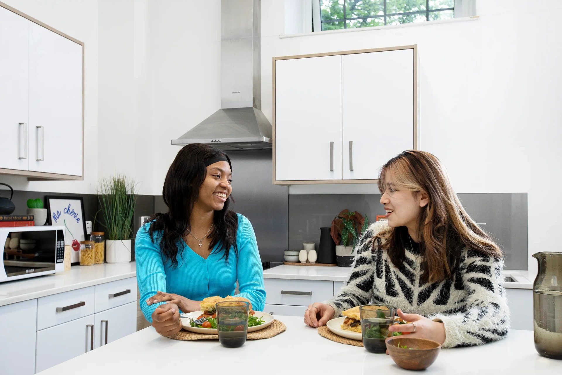 Two students eating in a modern kitchen kitchen at Arbour House in London Student Accommodation