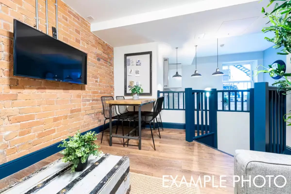 Brick wall TV dining table and stairs living area at The Shoe & Boot Factory in Leicester Student Accommodation