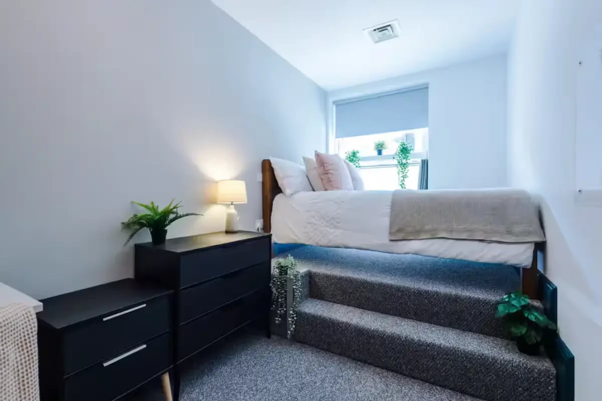 Bed with dresser and stairs bedroom at The Shoe & Boot Factory in Leicester Student Accommodation