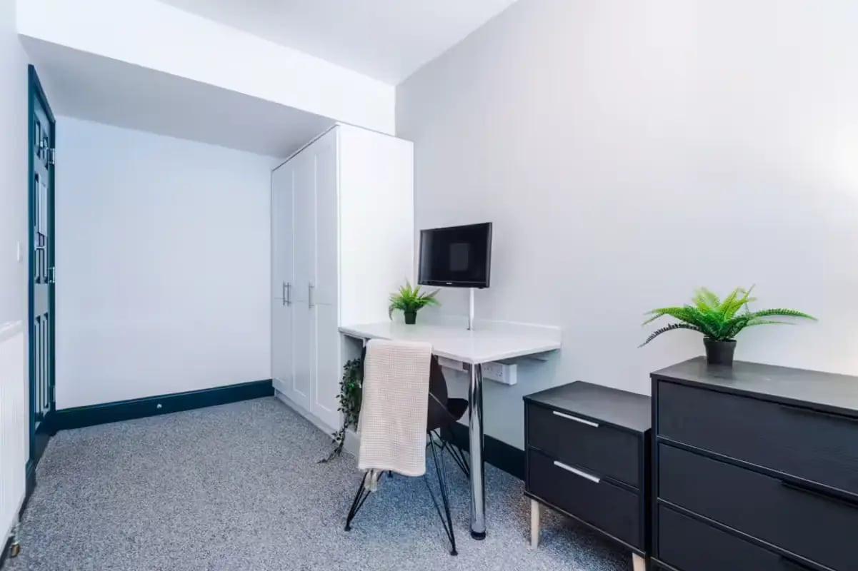 White wardrobe desk chair TV plant bedroom at The Shoe & Boot Factory in Leicester Student Accommodation