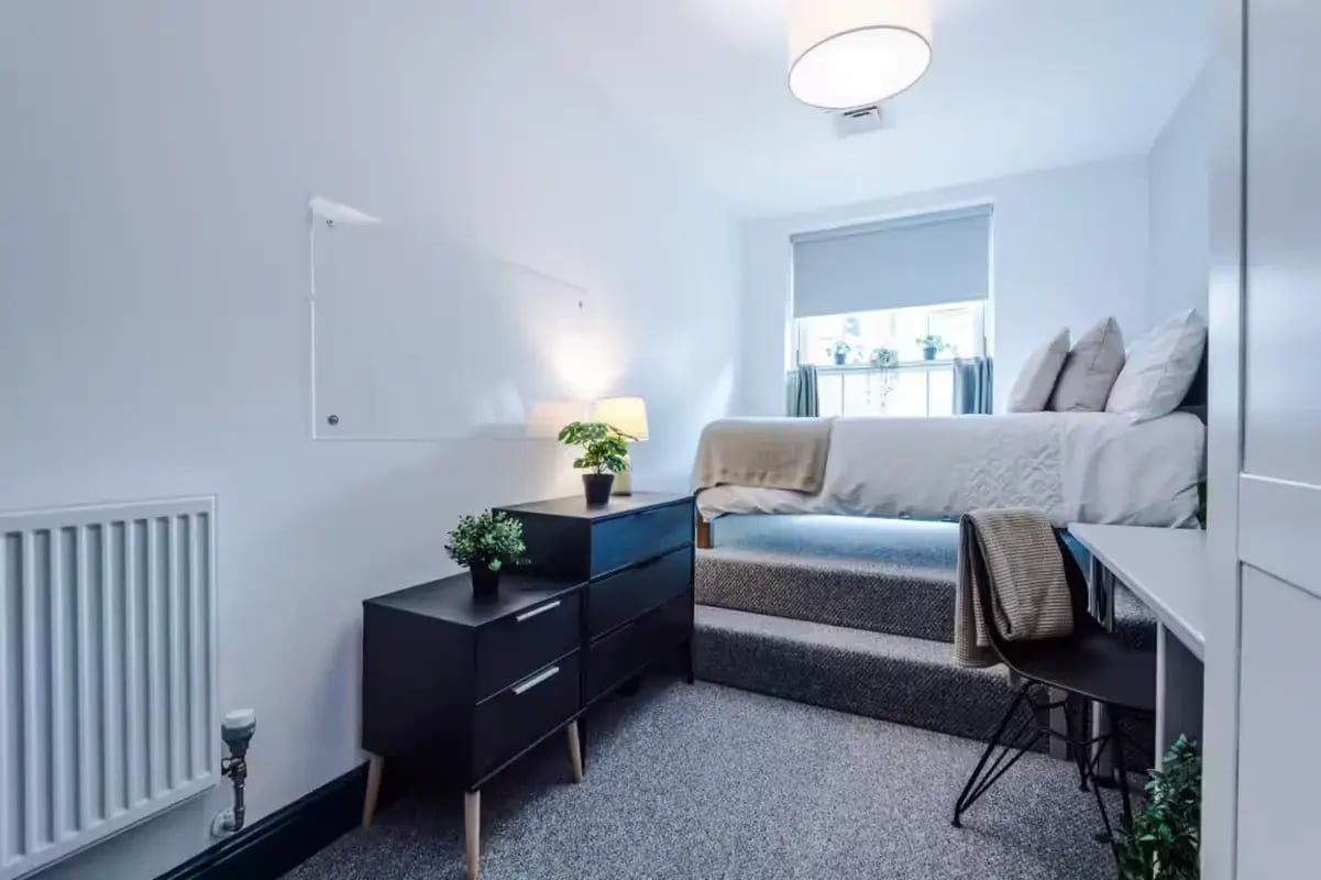 Bed dresser desk plants radiator bedroom at The Shoe & Boot Factory in Leicester Student Accommodation