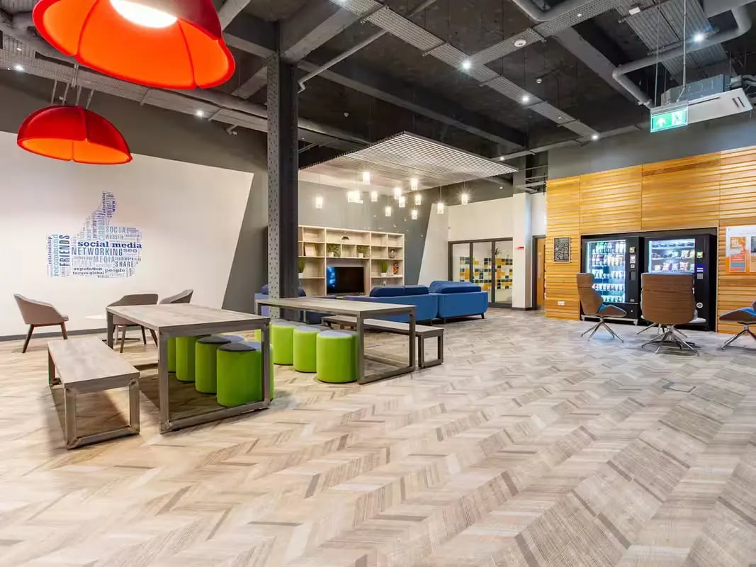 Social media wall tables and bright green stools common area at Plymouth Cross House in Plymouth Student Accommodation