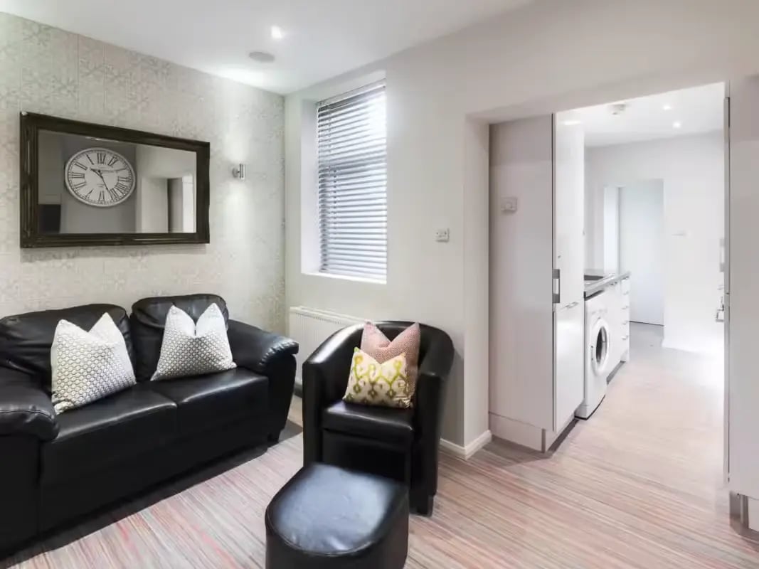 Black sofa chair ottoman kitchen living room at 219 Leek Road in Stoke-On-Trent Student Accommodation