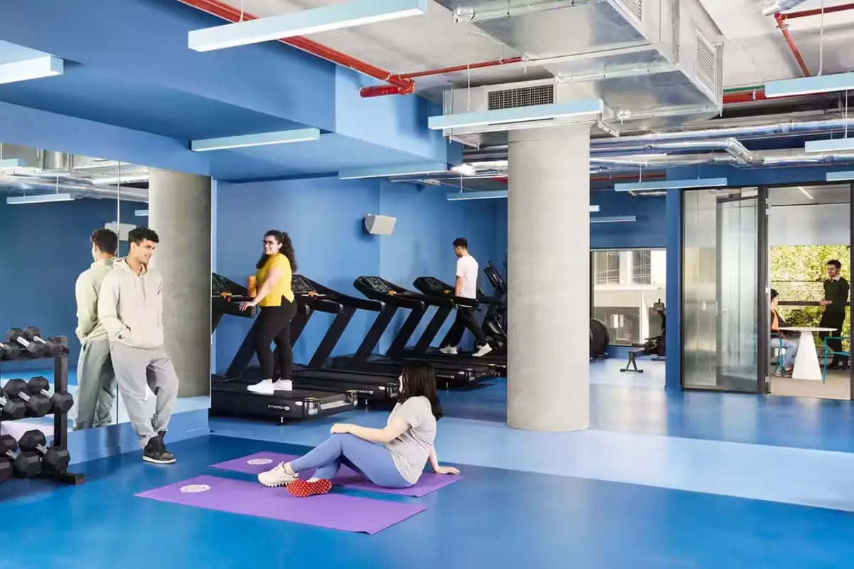 Gym with treadmills yoga mats and people working out gym at Scape Lincoln College in Melbourne Student Accommodation