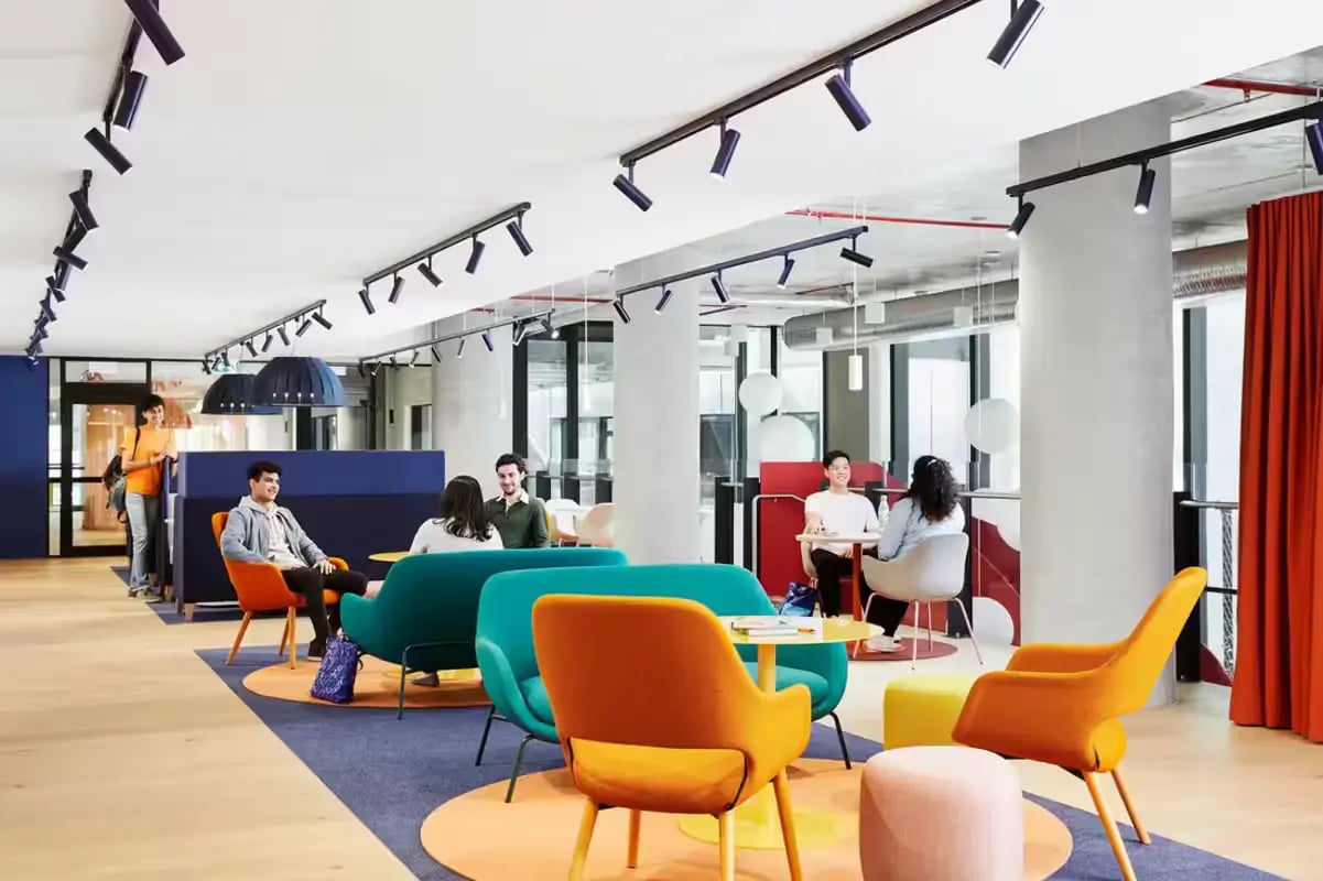Students sitting at tables and sofas common area at Scape Lincoln College in Melbourne Student Accommodation