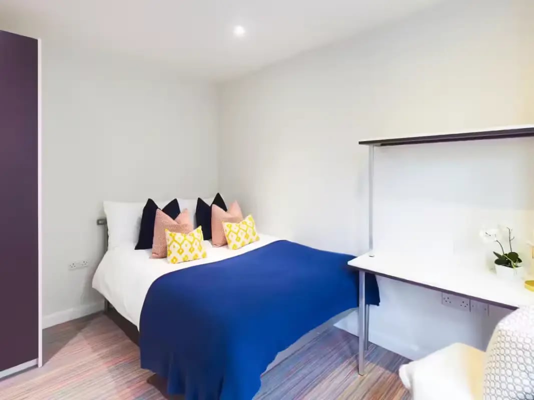 Bed with colorful pillows desk lamp and chair bedroom at 233 Leek Road in Stoke-On-Trent Student Accommodation