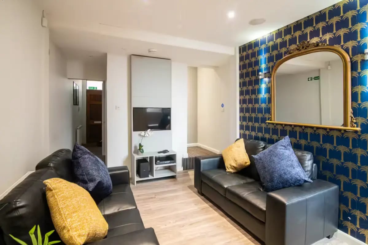 Two black sofas with decorative pillows living room at 231 Leek Road in Stoke-On-Trent Student Accommodation