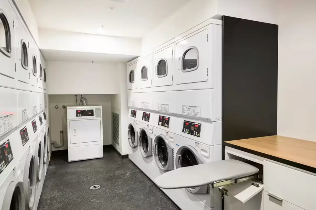 Multiple stacked washing machines and dryers laundry area at Scape La Trobe in Melbourne Student Accommodation