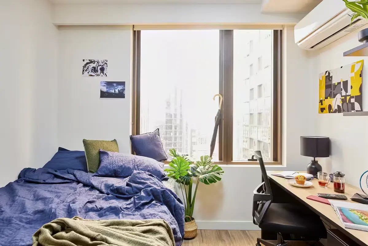 Blue bed desk plant window bedroom study at Scape La Trobe in Melbourne Student Accommodation