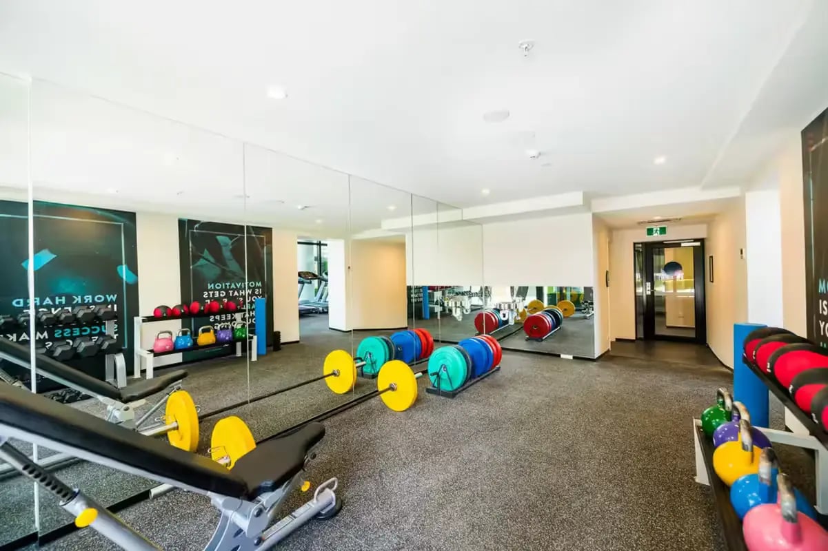 Gym with weights benches mirrors and treadmills Gym at Scape La Trobe in Melbourne Student Accommodation