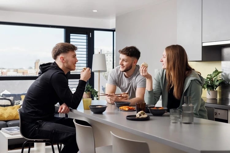 Three students eating at kitchen counter kitchen at Chaucer House in Portsmouth Student Accommodation