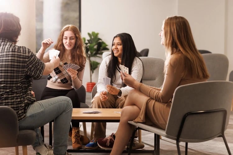 Students playing cards at a table living room at Chaucer House in Portsmouth Student Accommodation